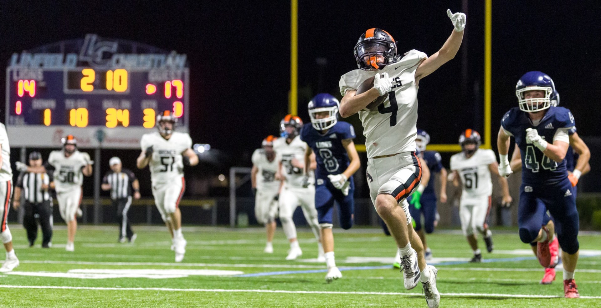 High school football player carrying the ball toward the end zone